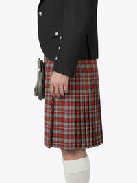 Person wearing a black jacket and red plaid kilt on a white background