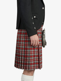Person wearing a black jacket and red plaid kilt on a white background