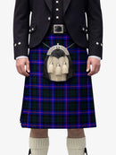 Person wearing a traditional Scottish kilt with a tartan pattern on a white background