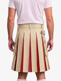 A man wearing a beige pleated kilt with red pleated inserts and silver buckle details, paired with a light pink t-shirt, shown from the back against a light gray background.