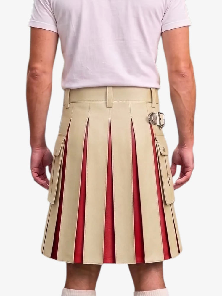 A man wearing a beige pleated kilt with red pleated inserts and silver buckle details, paired with a light pink t-shirt, shown from the back against a light gray background.