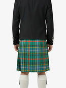 Person wearing a black jacket and green plaid kilt on a white background