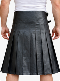 Black pleated leather skirt worn by a person on a white background