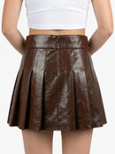 Brown pleated skirt worn by a person on a white background