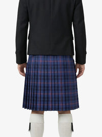 Person wearing a black jacket and blue plaid kilt on a white background