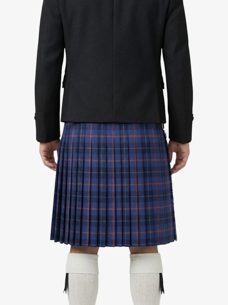Person wearing a black jacket and blue plaid kilt on a white background
