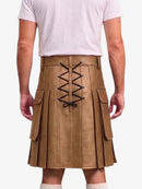 A person shown from the back wearing a tan pleated kilt with black lace-up detailing down the center and side cargo pockets, paired with a light pink t-shirt and white socks against a plain white background.