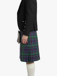 Person wearing a black blazer and tartan kilt on a white background