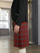 Person wearing a black blazer and red plaid skirt in an indoor setting.