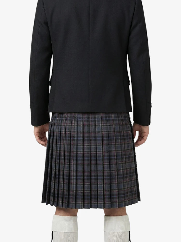 Person wearing a black jacket and plaid kilt on a white background