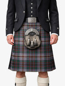 Person wearing a traditional Scottish kilt with a jacket and white socks on a white background