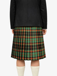 Person wearing a black jacket and green plaid kilt on a white background