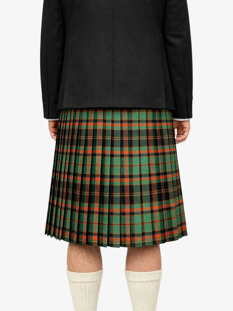 Person wearing a black jacket and green plaid kilt on a white background