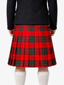 Person wearing a red plaid kilt with a black top on a white background