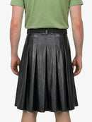 Person wearing a green shirt and black pleated skirt on a white background