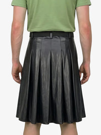 Person wearing a green shirt and black pleated skirt on a white background