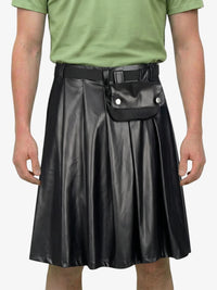 Person wearing a black leather skirt with a green shirt on a white background
