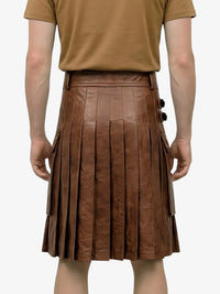 Brown pleated leather skirt worn by a person on a white background