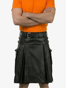Person wearing an orange shirt and black kilt on a white background