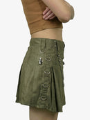 Green skirt with metal rings and a person wearing it on a white background