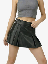 Person wearing a black pleated skirt and gray crop top on a white background