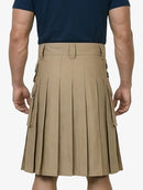 Person wearing a beige pleated kilt over a navy shirt on a white background