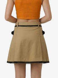 Beige skirt with black lace trim worn by a person on a white background