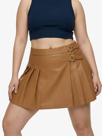 Person wearing a brown pleated skirt with gold buckles on a white background