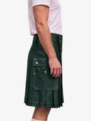 A dark green faux-leather kilt with pleated detailing and silver snap-button accents, shown on a model wearing a white t-shirt against a light gray background.