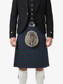 Person wearing a traditional Scottish kilt with a tartan pattern on a white background