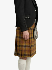 Person wearing a black jacket and plaid kilt on a white background