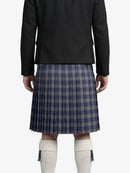 Person wearing a black jacket and plaid kilt on a white background