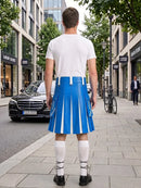 A man stands on a city sidewalk facing away from the camera, wearing a white T-shirt and a bright blue pleated kilt with white vertical stripes, white knee-high socks, and black shoes. Buildings, trees, a black car, and a bicycle are visible in the background.