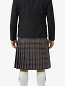 Person wearing a black jacket and plaid kilt on a white background