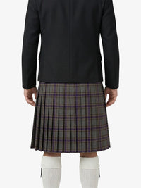 Person wearing a black jacket and plaid kilt on a white background