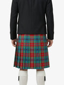Person wearing a black jacket and a red, green, and blue plaid kilt on a white background