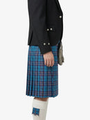 Person wearing a black jacket and blue plaid kilt on a white background
