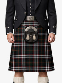 Person wearing a traditional Scottish kilt with a dark jacket and white socks.