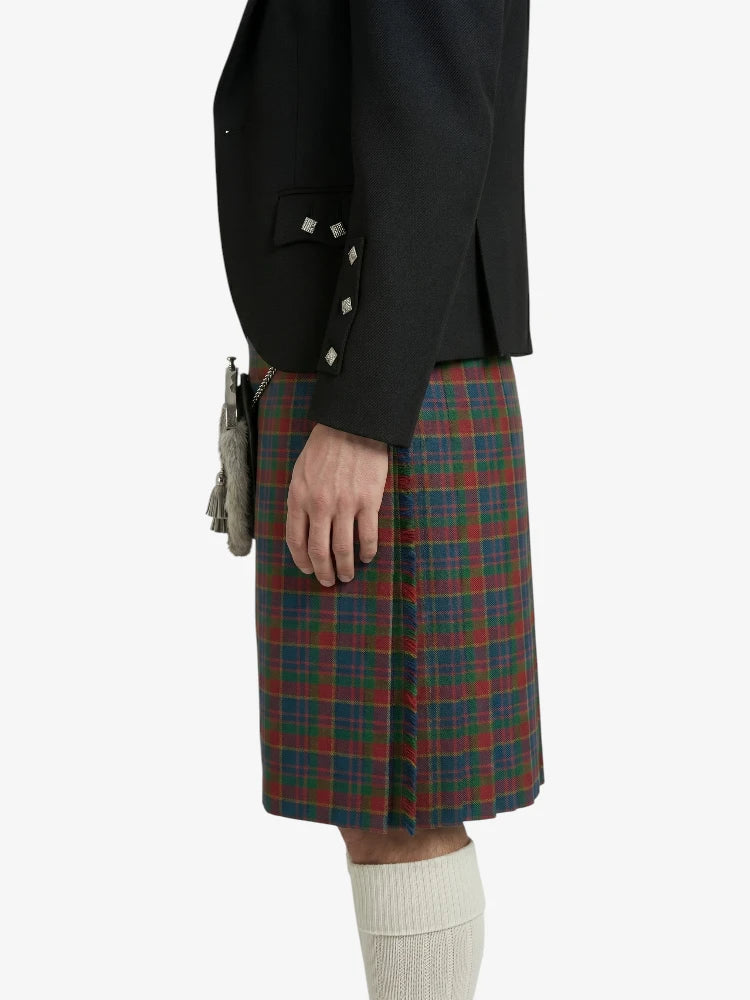 Person wearing a black jacket and plaid kilt on a white background