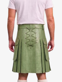 A person shown from the back wearing a sage green pleated leather kilt with a central lace-up closure and side cargo pockets, paired with a light pink t-shirt and white socks.