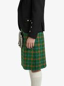 Person wearing a green plaid kilt with a black jacket on a white background