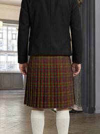 Person wearing a black jacket and plaid kilt indoors.