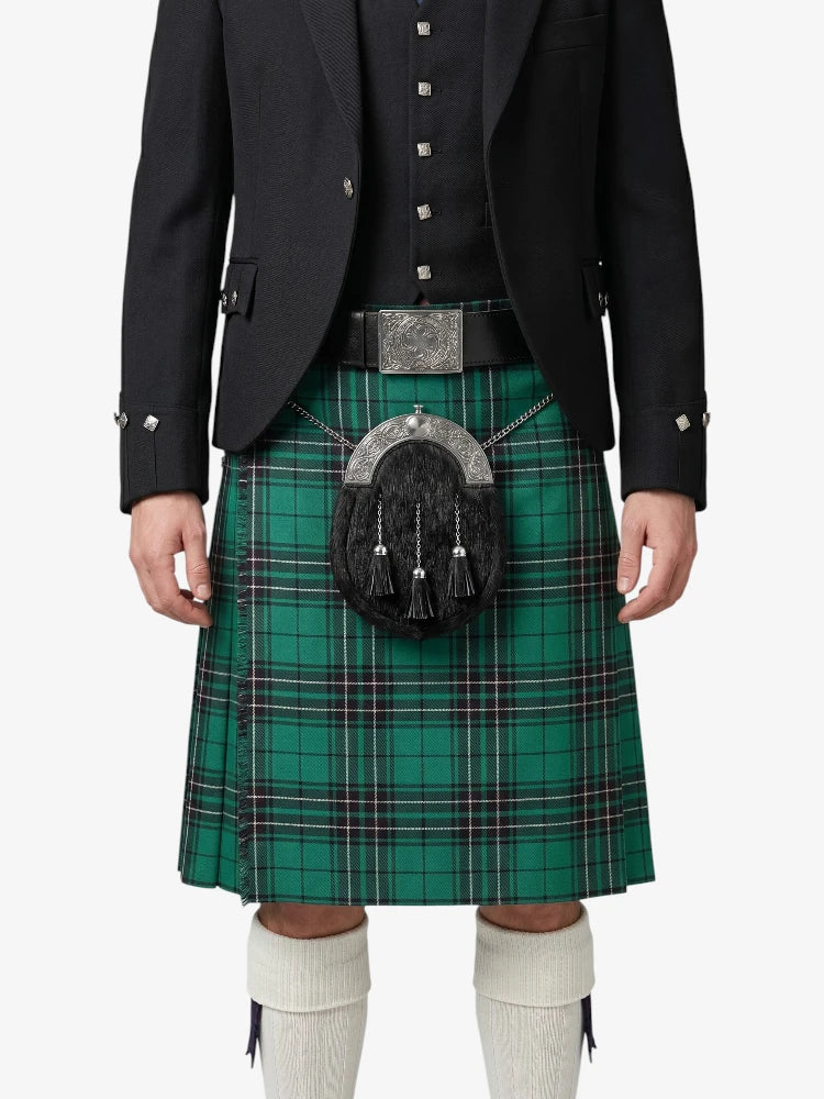 Person wearing a green plaid kilt with a black jacket on a white background