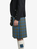 Person wearing a black jacket and blue plaid kilt on a white background
