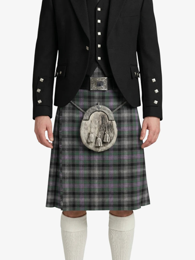 Person wearing a traditional Scottish kilt with a jacket on a white background