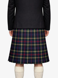 Person wearing a black blazer and plaid kilt on a white background