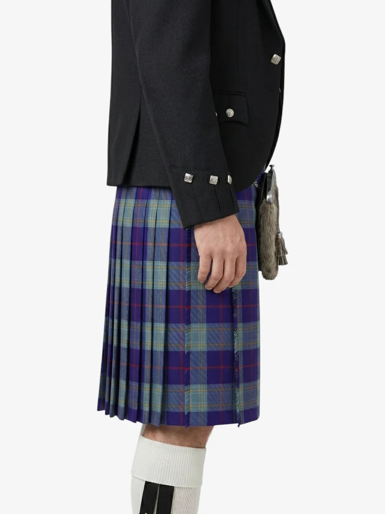 Person wearing a black jacket and a plaid kilt on a white background