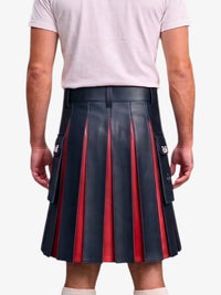 A person shown from the back wearing a pleated leather kilt with alternating dark navy and red vertical pleats, paired with a light pink t-shirt and white socks, against a plain light gray background.