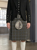 Person wearing a traditional Scottish kilt with a jacket indoors.