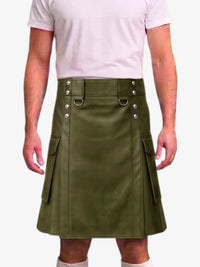 A man wearing an olive green faux-leather kilt with silver-tone metal hardware and side cargo pockets, paired with a light pink t-shirt and white socks, against a plain white background.